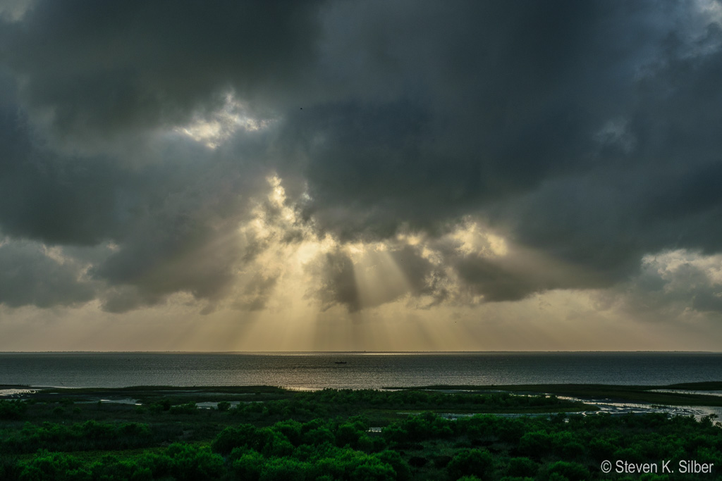 Setting sun behind storm clouds, with Sunbeams coming through holes in the clouds. (1/400 sec at f / 14,  ISO 100,  38 mm, 18.0-55.0 mm f/3.5-5.6 ) June 29, 2017